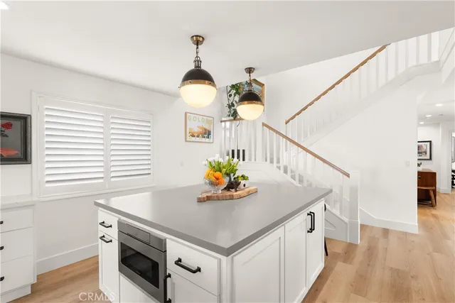 a view of kitchen island with stainless steel appliances granite countertop center island and wooden floor