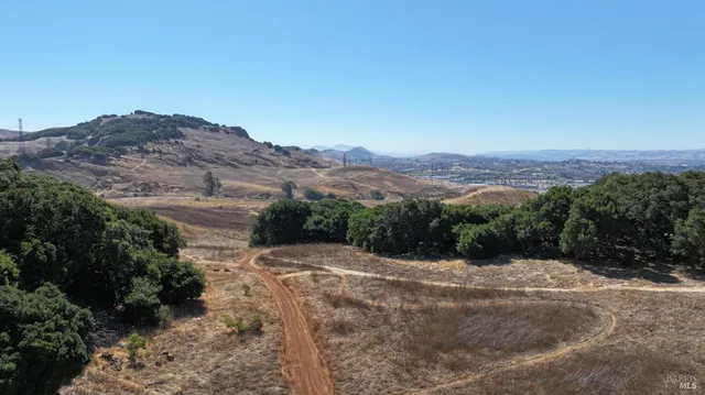 a view of a dry yard with mountains in the background