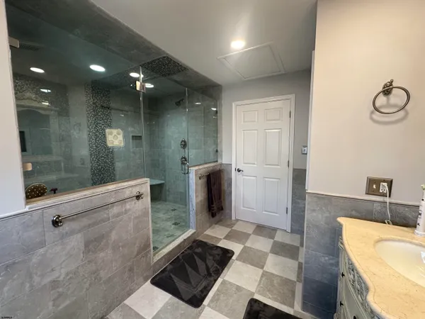 a spacious bathroom with a double vanity sink a mirror and a shower