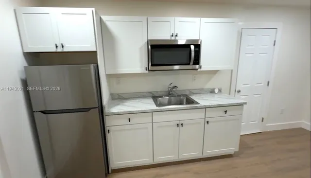a kitchen with stainless steel appliances a refrigerator a sink and a microwave