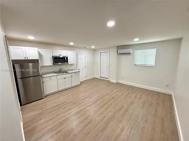 a kitchen with stainless steel appliances a refrigerator sink and microwave