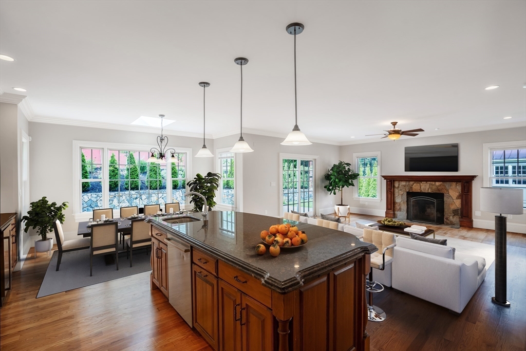 52 North Border Road, Unit 52 Winchester, MA 01890 - Photo 21 of 34 a open kitchen with stainless steel appliances granite countertop a stove a refrigerator a kitchen island a couch and a wooden floor