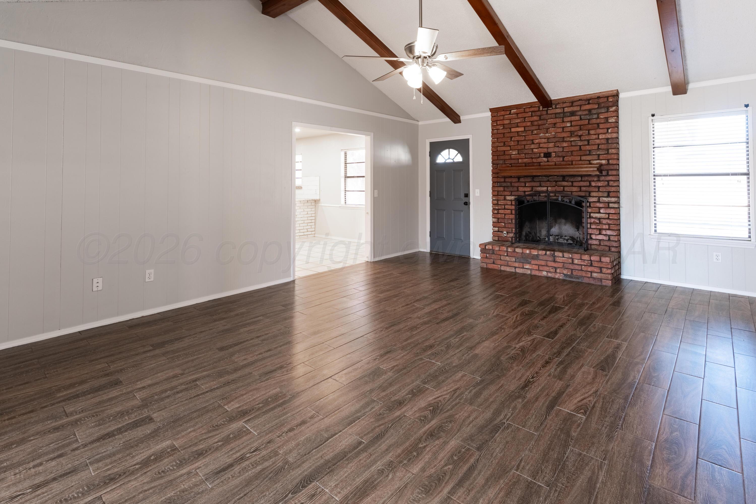 2907 Mable Drive Canyon, TX 79015 - Photo 4 of 19 a view of an empty room with wooden floor fireplace and a window