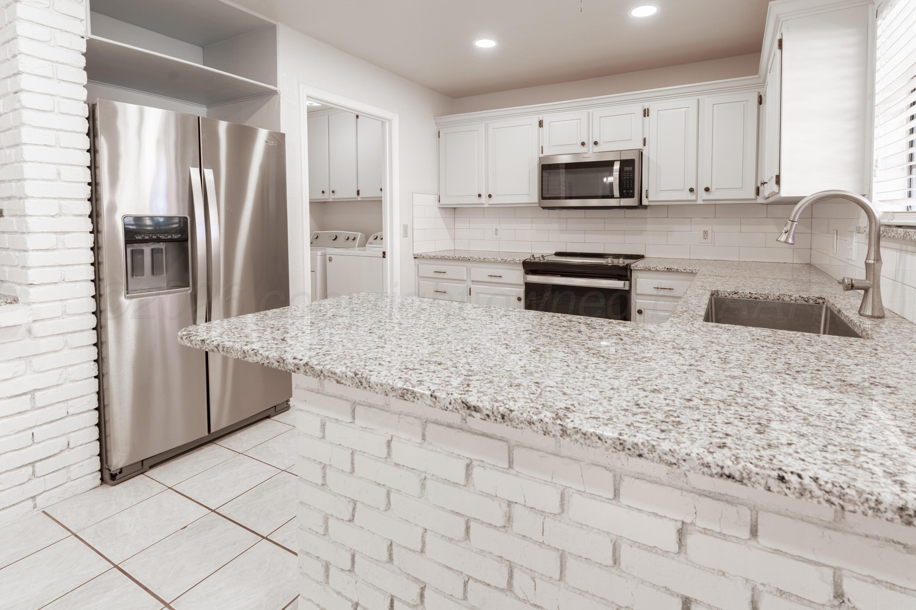 2907 Mable Drive Canyon, TX 79015 - Photo 7 of 19 a kitchen with granite countertop a refrigerator and a sink