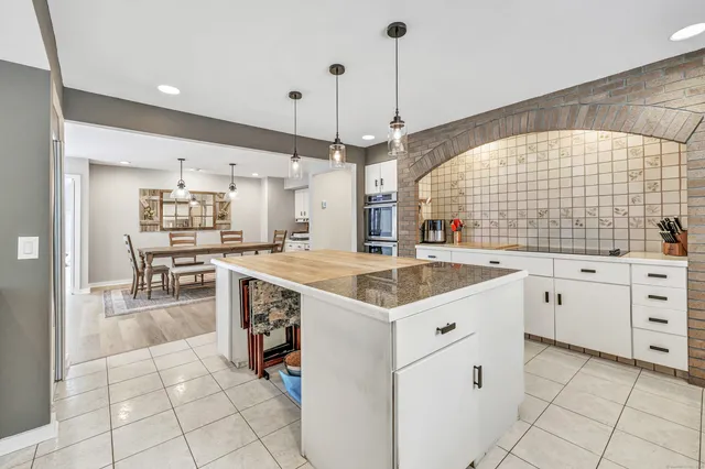 a kitchen with white cabinets and sink