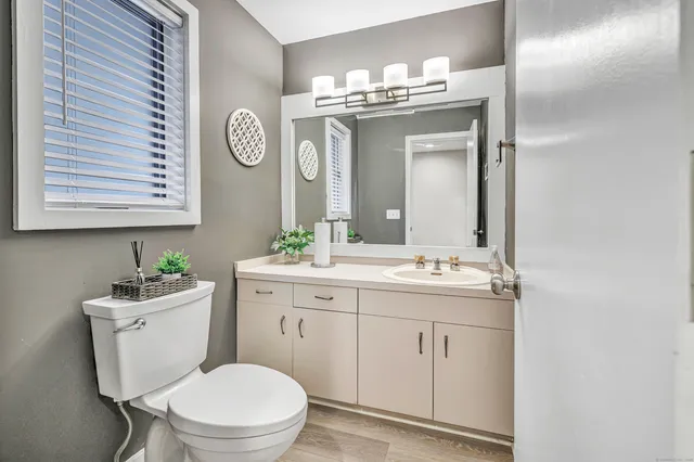 a bathroom with a toilet a sink a mirror and vanity