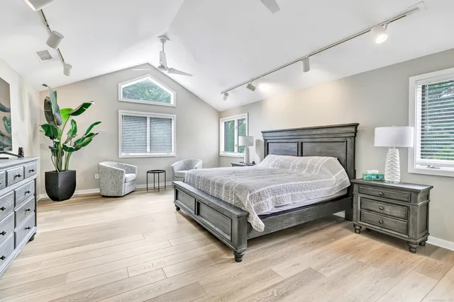 a bedroom with a bed a table and a potted plant