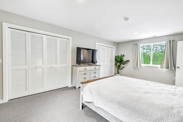 a bedroom with a large bed and a flat screen tv