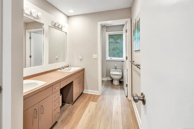a spacious bathroom with a granite countertop sink toilet and shower
