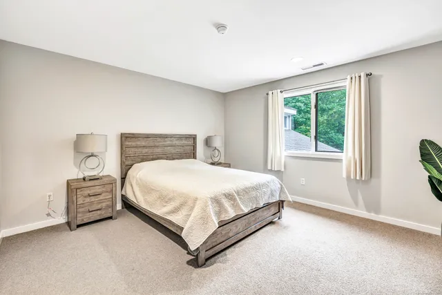 a bed sitting in a bedroom next to a window