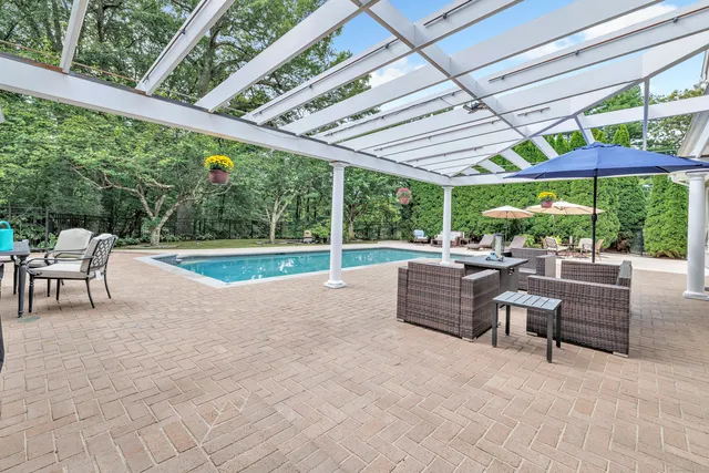 a view of a patio with a table and chairs under an umbrella