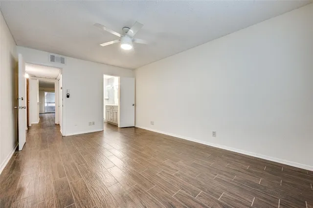 a view of an empty room with wooden floor