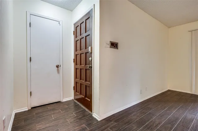 a view of a hallway with wooden floor and closet
