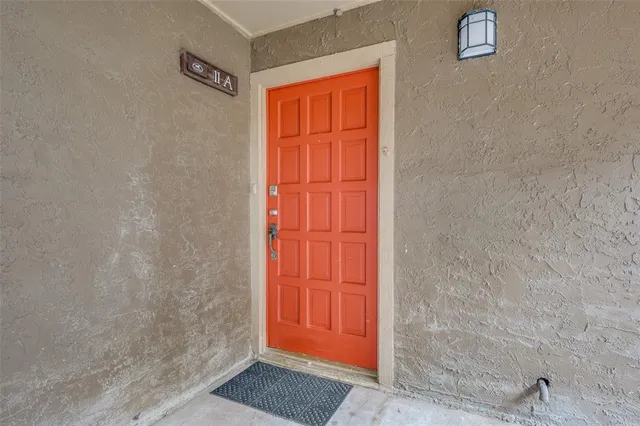 a view of a swimming pool with tables and chairs under an umbrella