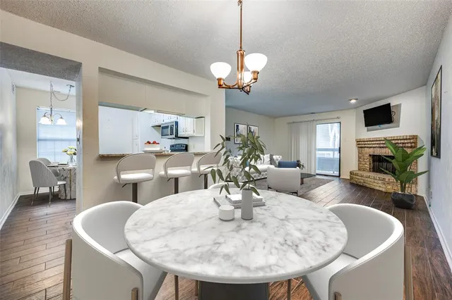 a view of a dining room with furniture a fireplace and wooden floor