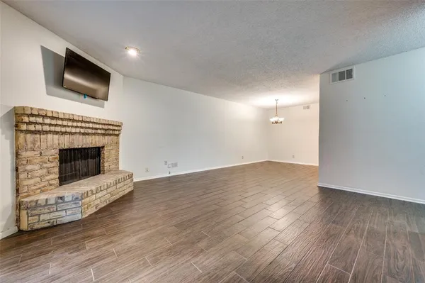 a view of empty room with wooden floor and fireplace