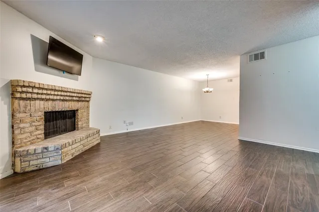 a view of empty room with wooden floor and fireplace