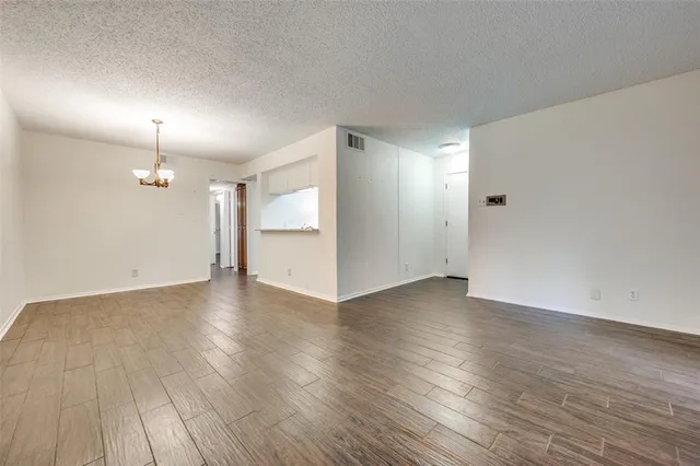 an empty room with wooden floor and window