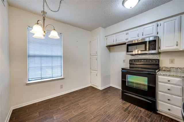 a kitchen with stainless steel appliances a stove microwave and cabinets
