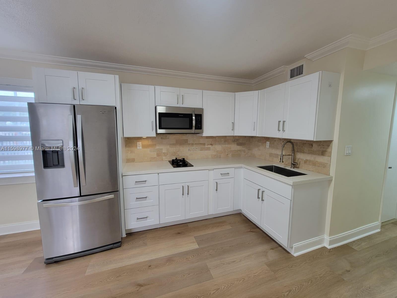 30701 Southwest 150th Avenue, Unit C Homestead, FL 33033 - Photo 13 of 30 a kitchen with granite countertop white cabinets and stainless steel appliances