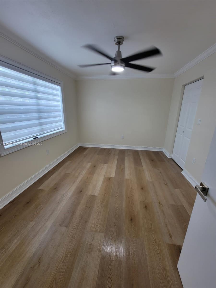 30701 Southwest 150th Avenue, Unit C Homestead, FL 33033 - Photo 20 of 30 an empty room with wooden floor fan and windows