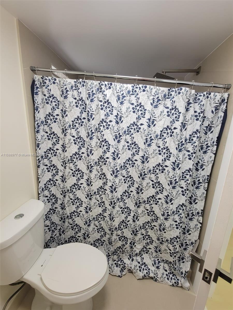 30701 Southwest 150th Avenue, Unit C Homestead, FL 33033 - Photo 28 of 30 a bathroom with a toilet and a shower curtain