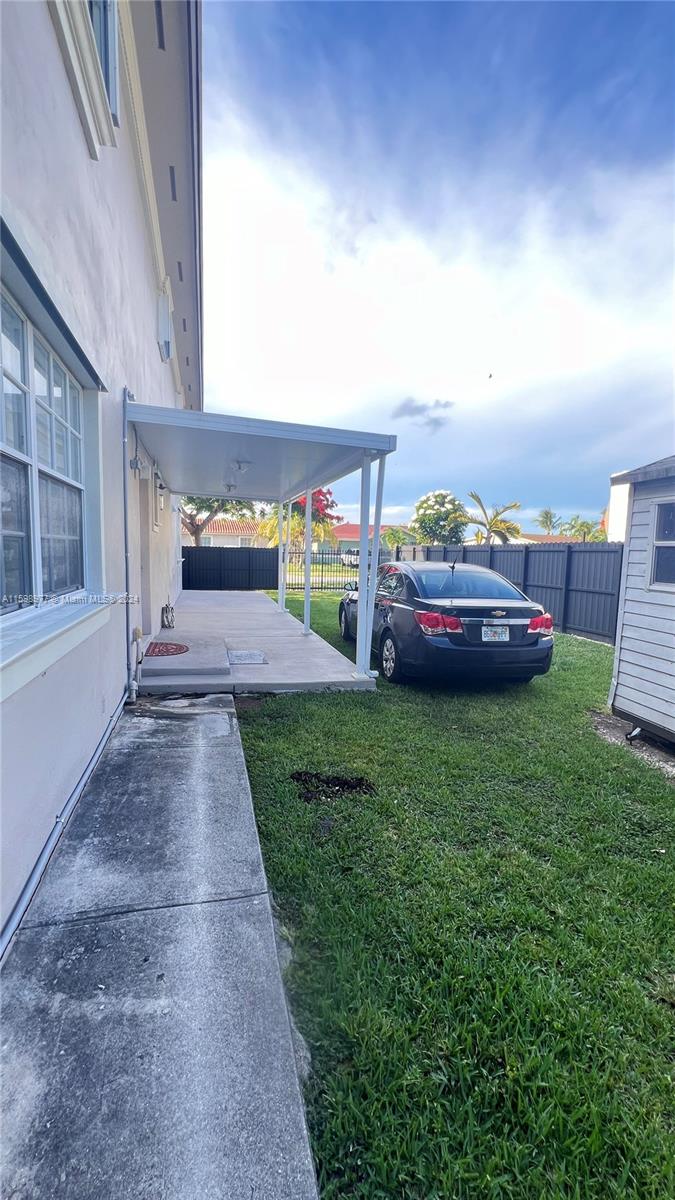 30701 Southwest 150th Avenue, Unit C Homestead, FL 33033 - Photo 5 of 30 a front view of a house with a garden and yard