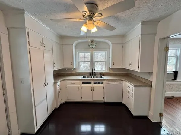 a kitchen with white cabinets and white appliances