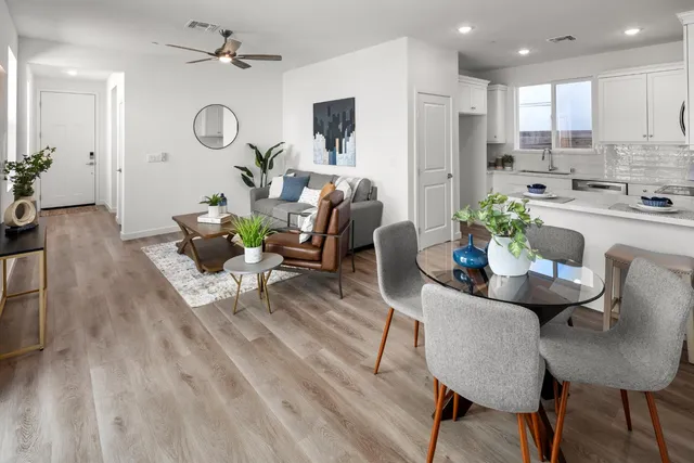 a living room with furniture kitchen view and a chandelier