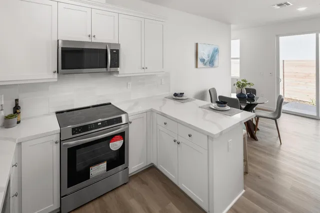 a kitchen with stainless steel appliances a stove a microwave and sink