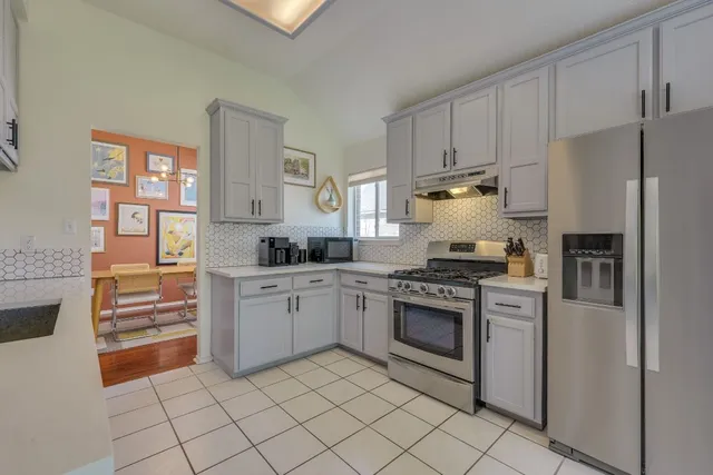 a kitchen with granite countertop white cabinets and stainless steel appliances