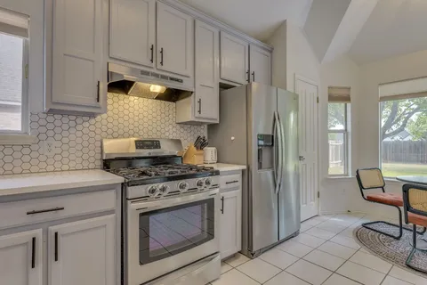 a kitchen with cabinets appliances and a counter space