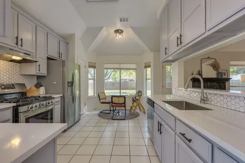 a kitchen with stainless steel appliances granite countertop a sink and a stove