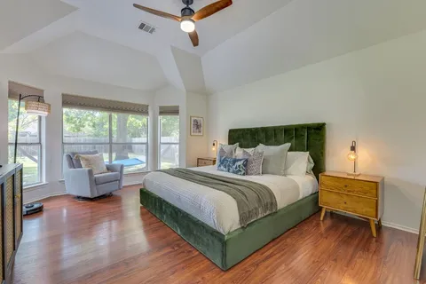 a bedroom with a bed and large windows