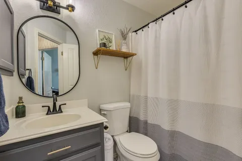 a bathroom with a sink a toilet and a mirror