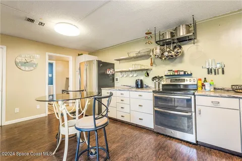 a kitchen with a stove cabinets and chairs