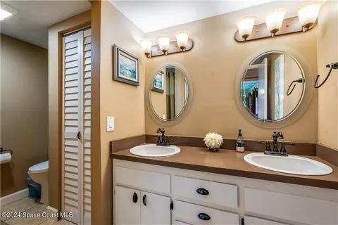 a bathroom with double vanity sinks and a mirror