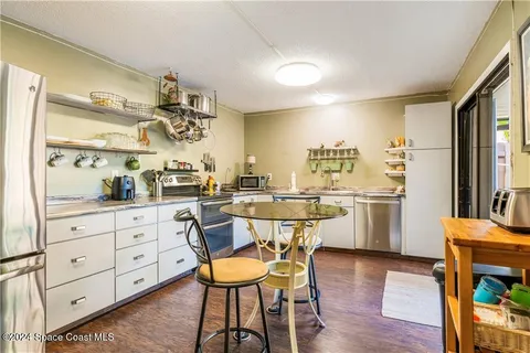 a kitchen with a table chairs refrigerator and cabinets