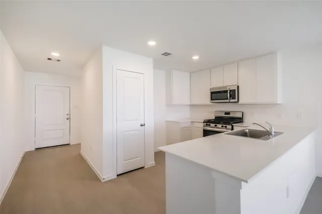 a kitchen with a sink a stove cabinets and a refrigerator