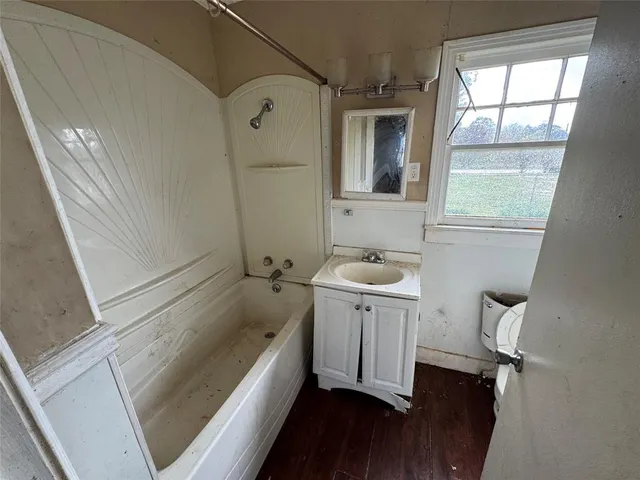 a bathroom with a tub sink and mirror