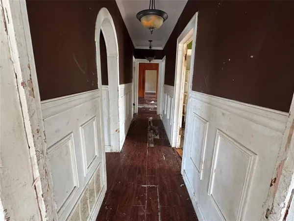 a view of a hallway with wooden floor and staircase