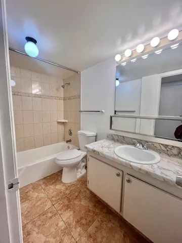 a bathroom with a sink a toilet a mirror and shower