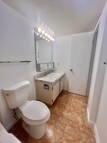 a bathroom with a sink toilet and a mirror