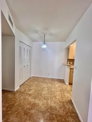 a view of a livingroom with wooden floor and a refrigerator
