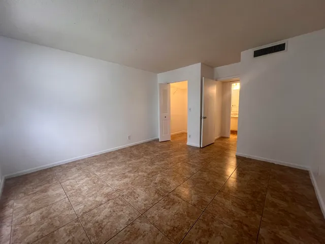 an empty room with closet and windows