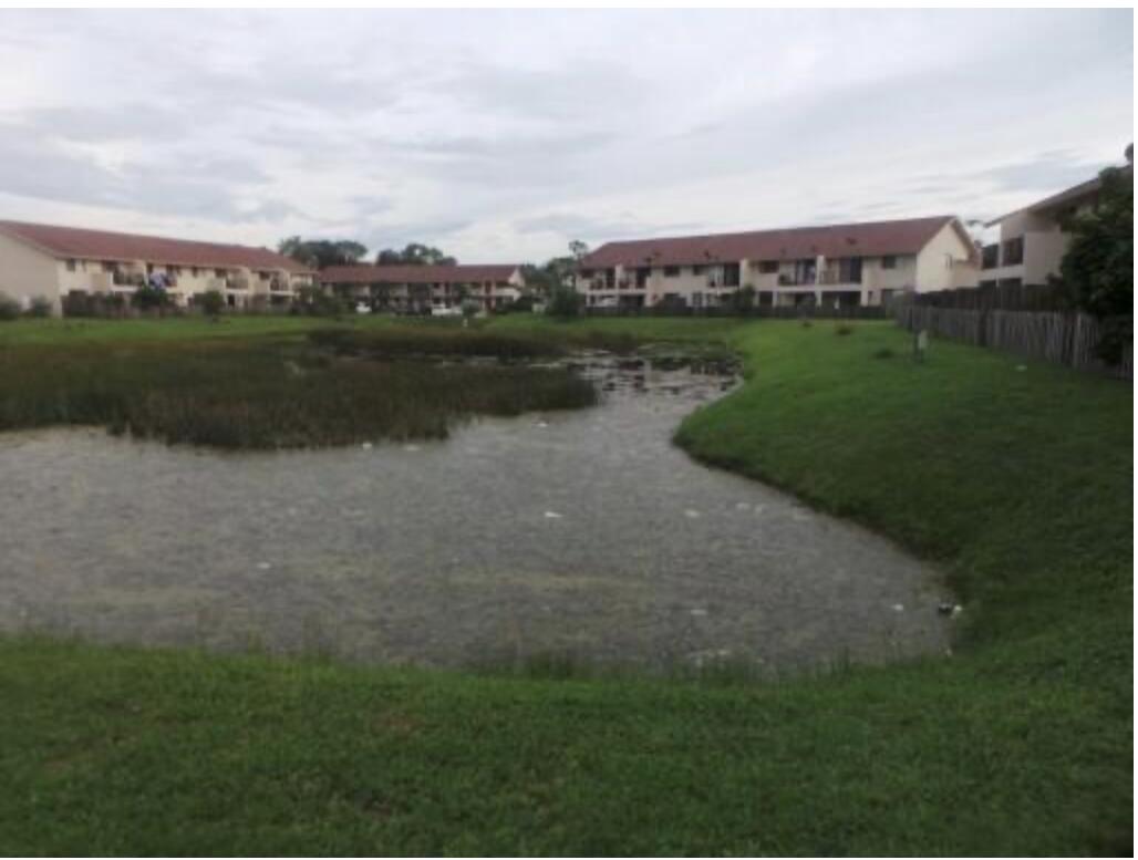 200 Nottingham Circle, Unit J Greenacres, FL 33463 - Photo 2 of 12 a view of a lake with houses in the back
