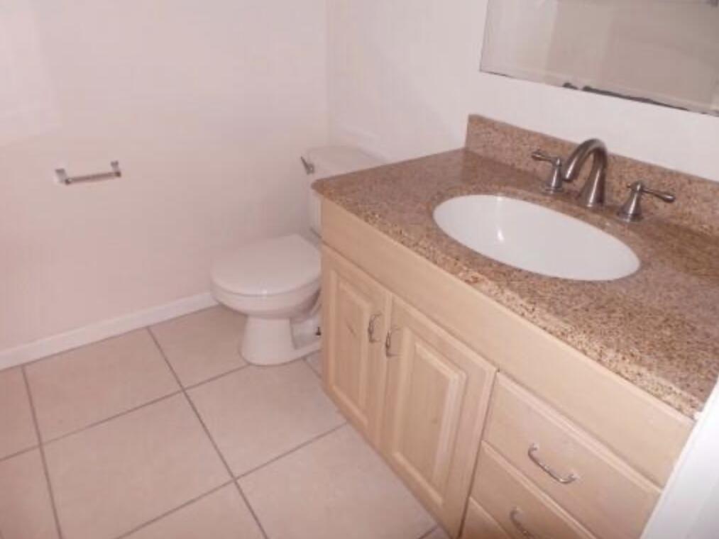 200 Nottingham Circle, Unit J Greenacres, FL 33463 - Photo 7 of 12 a bathroom with a granite countertop sink and a mirror