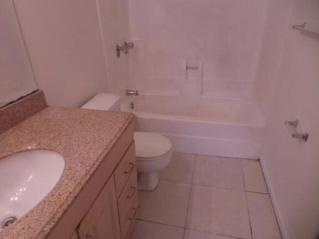 200 Nottingham Circle, Unit J Greenacres, FL 33463 - Photo 8 of 12 a bathroom with a granite countertop sink toilet and shower