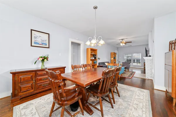 a view of a dining room and livingroom with furniture wooden floor a chandelier