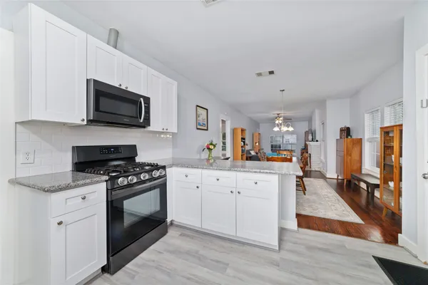 a kitchen with stainless steel appliances a stove microwave and sink